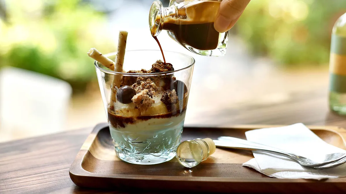 Eiskaffee wird mit Kaffeelikör verziert