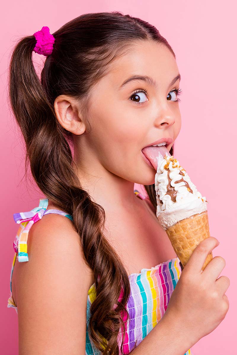 Mädchen leckt an Eisbecher