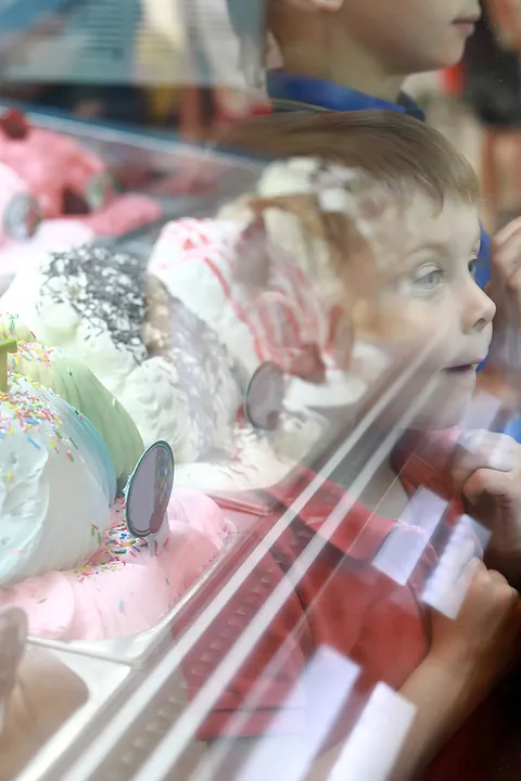 Spiegelung eines kleinen Jungen in Eisauslage