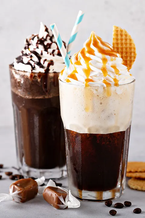 Eiskaffee angerichtet mit Waffeln, STrohhalm und Kaffeebohnen